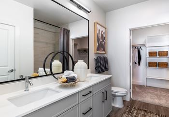 A bathroom with a white sink and a mirror above it.